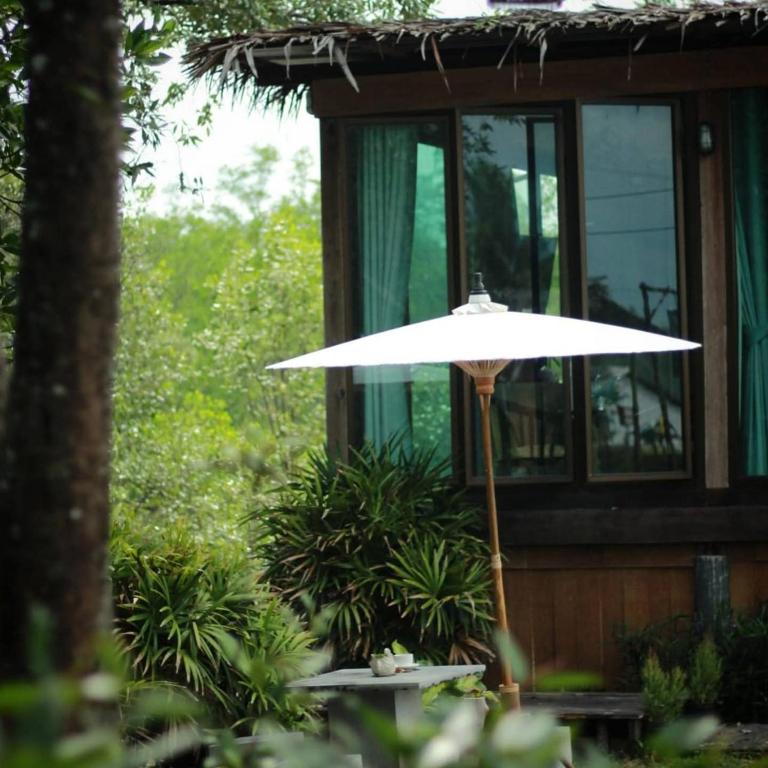 a white umbrella in front of a house at Calm at Bangphat in Ban Khiam