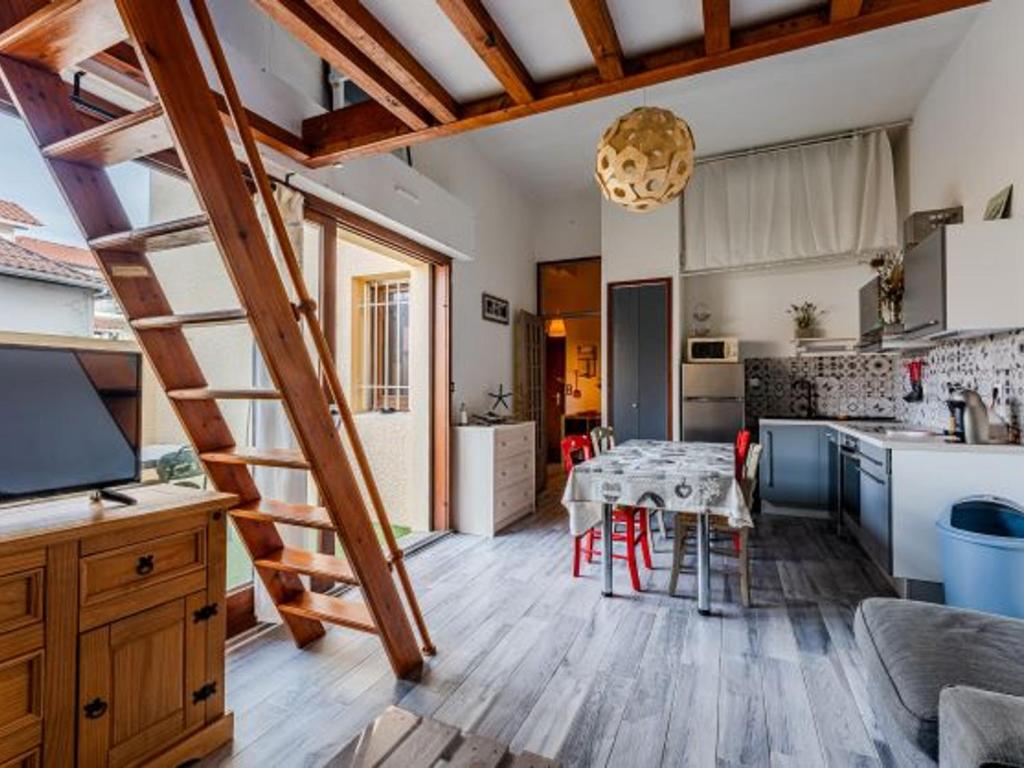 eine Küche und ein Esszimmer mit einem Tisch und einer Treppe in der Unterkunft Charmant appartement avec mezzanine et parking - 4 pers - FR-1-521-263 in Biscarrosse-Plage