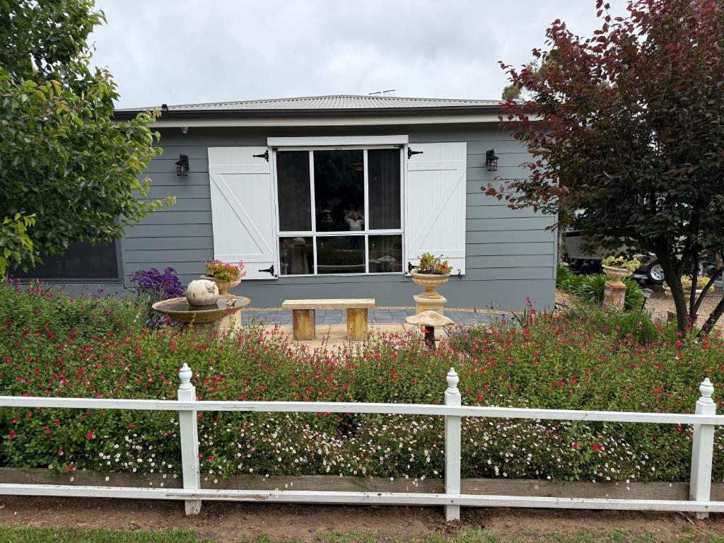 ein weißer Zaun vor einem Haus in der Unterkunft Cozy Cottage Victor Harbor in Hindmarsh Valley