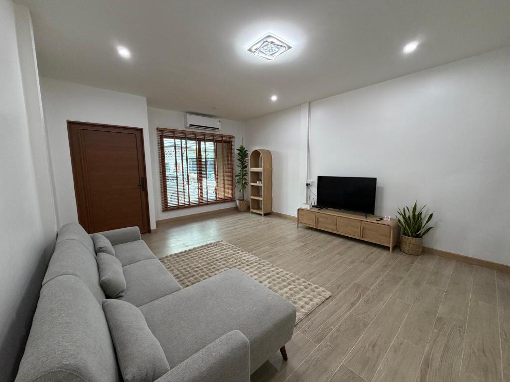 ハジャイにあるAma'homeのソファと薄型テレビのあるリビングルーム