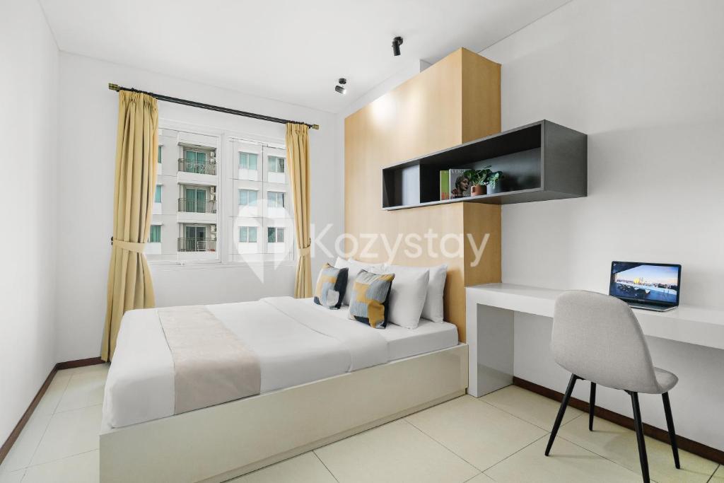 a bedroom with a bed and a desk at Javen by Kozystay - Thamrin in Jakarta