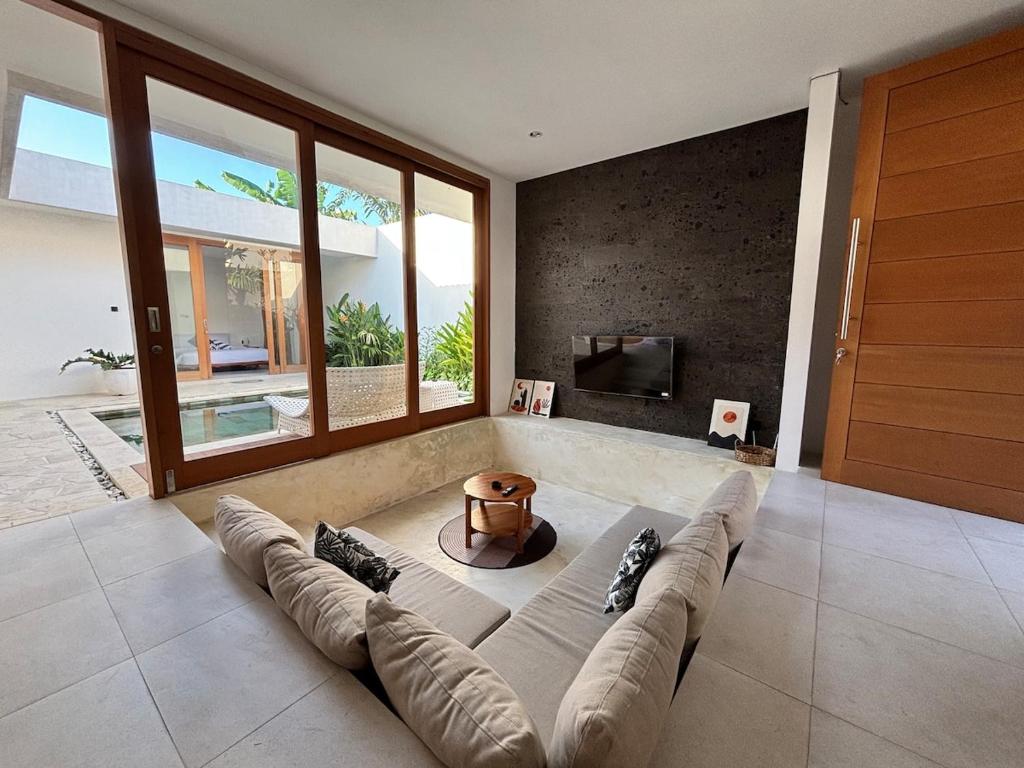 a living room with a couch and a fireplace at Casa Gemellia Brand New 2BR in Umalas in Kerobokan