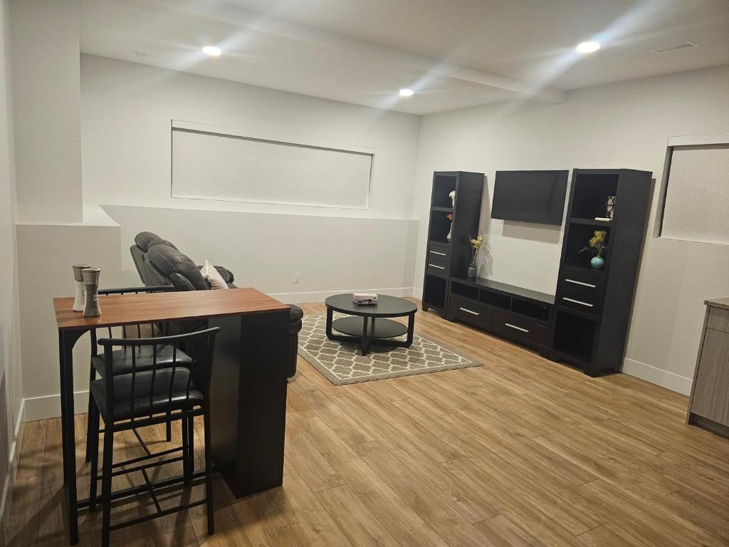 a living room with a bar and a tv and a table at Spacious 1 BRD Basement Suite in Prince George