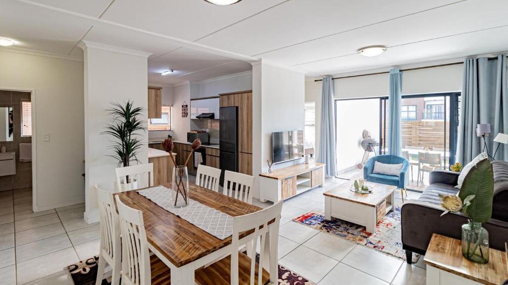 una cucina e un soggiorno con un tavolo e un soggiorno di The Blyde @ 485 a Pretoria