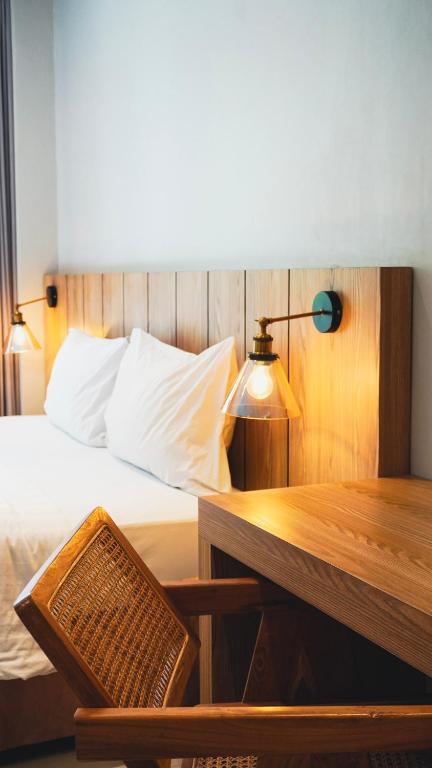 a bedroom with a bed and a table and a desk at Grand Kuta Hotel and Residence in Legian