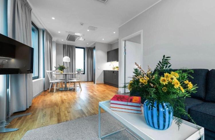 un salon avec un vase de fleurs sur une table dans l'établissement BLACK PEARL DELUXE Apartments In OLD TOWN, à Szczecin