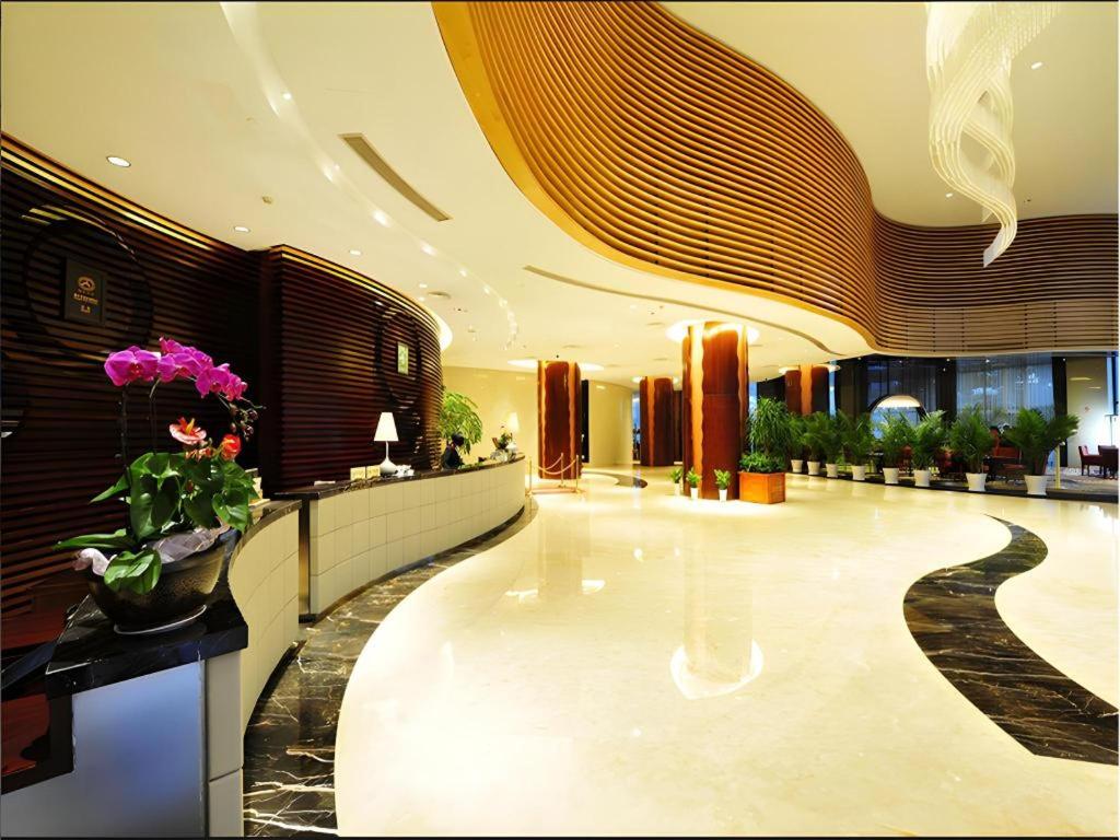 a lobby of a building with flowers on the floor at New Century Hangzhou Qiandao Lake Longting Hotel in Thousand Island Lake