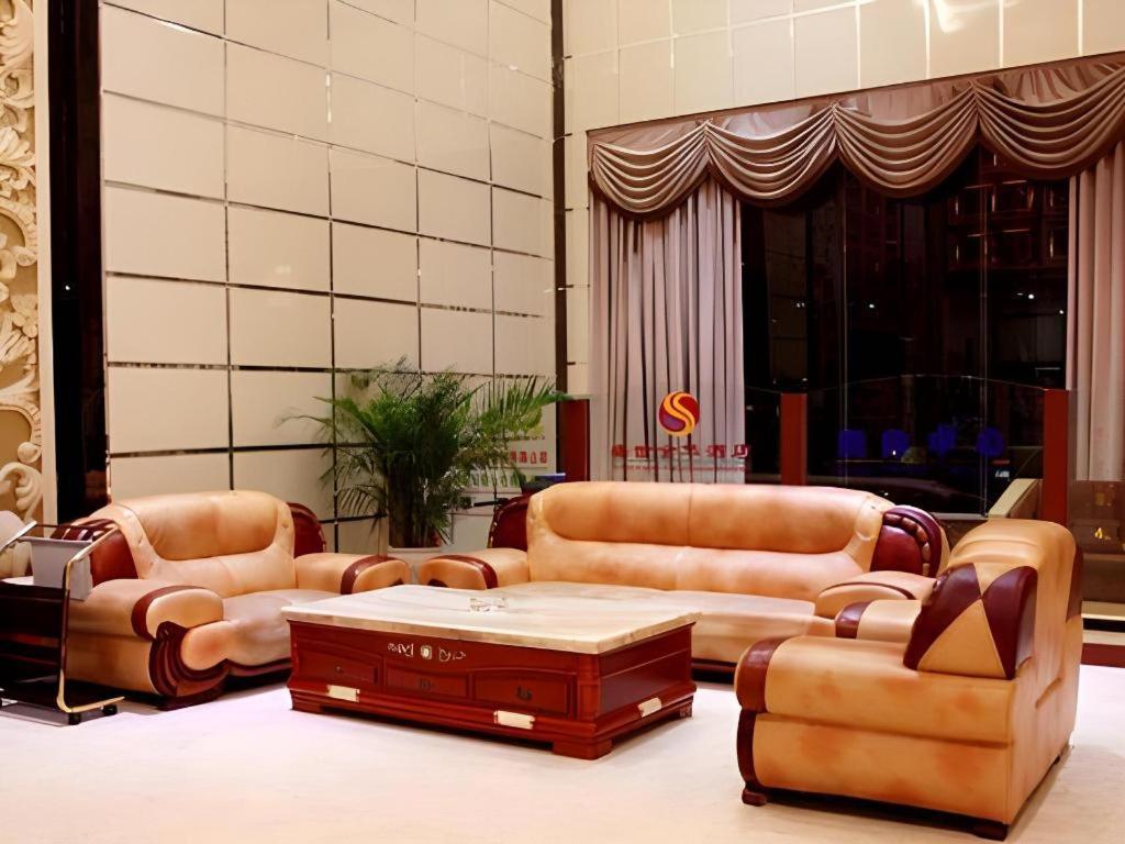 a lobby with leather couches and a coffee table at Shengshi Jinhua Hotel in Longgang