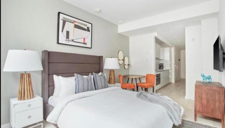 une chambre blanche avec un lit, une table et des chaises dans l'établissement BLACK PEARL FAMILY Apartments In CENTRUM, à Szczecin