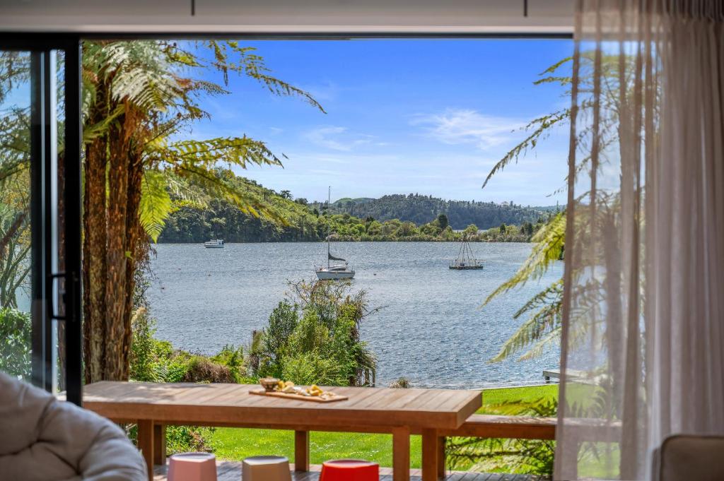 a view of a lake from a house window at Okawa Bay Lakeside - Lake Rotoiti A-Frame in Mourea