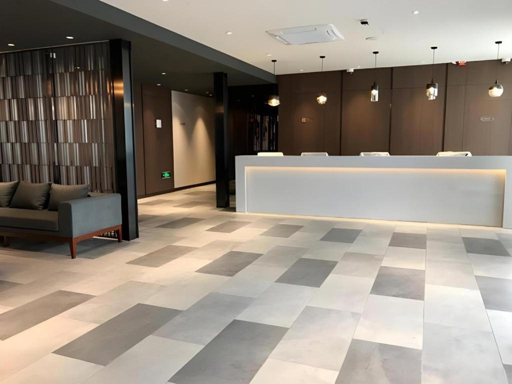un hall d'entrée avec un bureau de réception dans un immeuble dans l'établissement Jinjiang Inn Select Shanghai International Resort Area East Kangqiao Road, à Shanghai