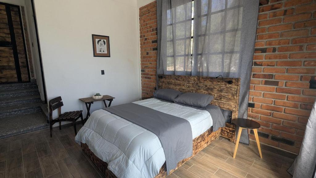 una camera da letto con un letto e un muro di mattoni di Casa Ñogi 