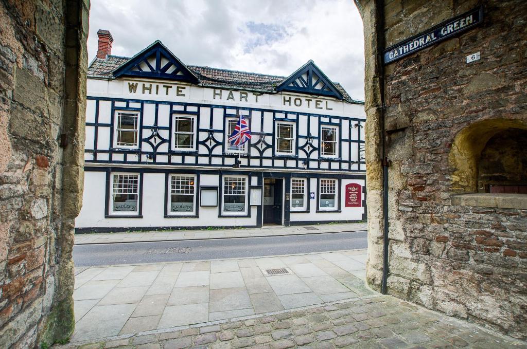 a white harriott hotel on a city street at White Hart Inn in Wells