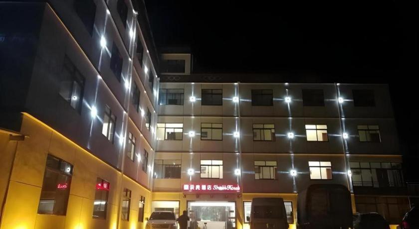 a building with lights on top of it at night at Shell Linzhi Bayi Area G318 Shuangyong Road Hotel in Dagzê