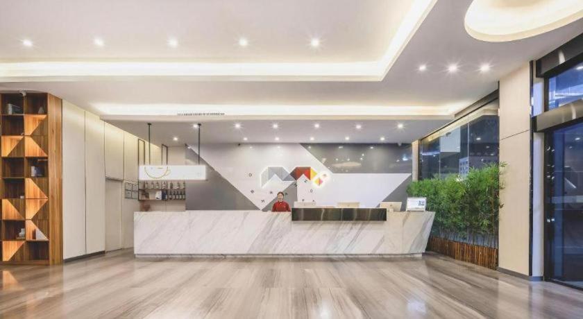 eine Lobby mit einer Treppe in einem Gebäude in der Unterkunft Borrman Hotel Fangchenggang High-speed Railway North Station Crystal International in Fangchenggang