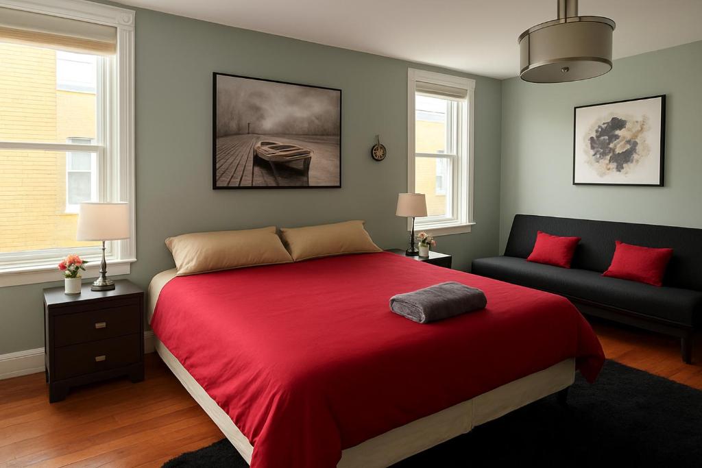 1 dormitorio con cama roja y sofá en Heart of Toronto Home, en Toronto
