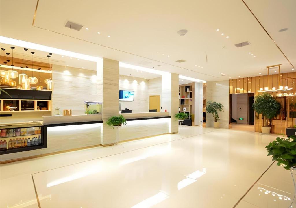 eine Lobby eines Gebäudes mit weißen Böden und Pflanzen in der Unterkunft City Comfort Inn Xiaogan Hubei Engineering College in Xiaogan