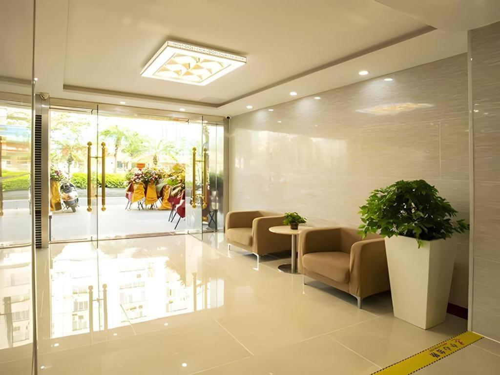 a lobby with chairs and a table with a plant at JTOUR Inn Zhanjiang Poly Yuandian Plaza in Zhanjiang