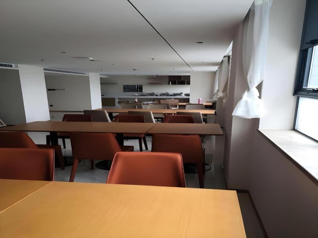 an empty classroom with tables and chairs and a window at City Comfort Inn Kunshan High-speed Railway Station Renmin Road in Kunshan