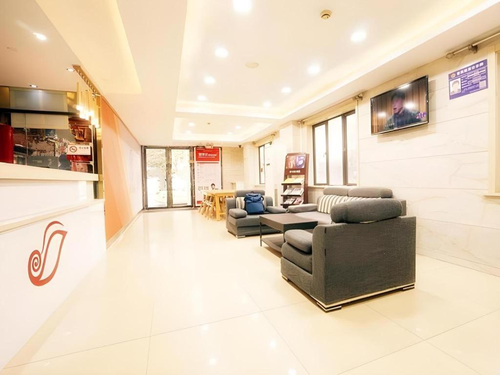 ein Wohnzimmer mit Sofas und Stühlen in einem Gebäude in der Unterkunft Shell Hotel Shanghai Expo Changqing Road Metro Station in Shanghai