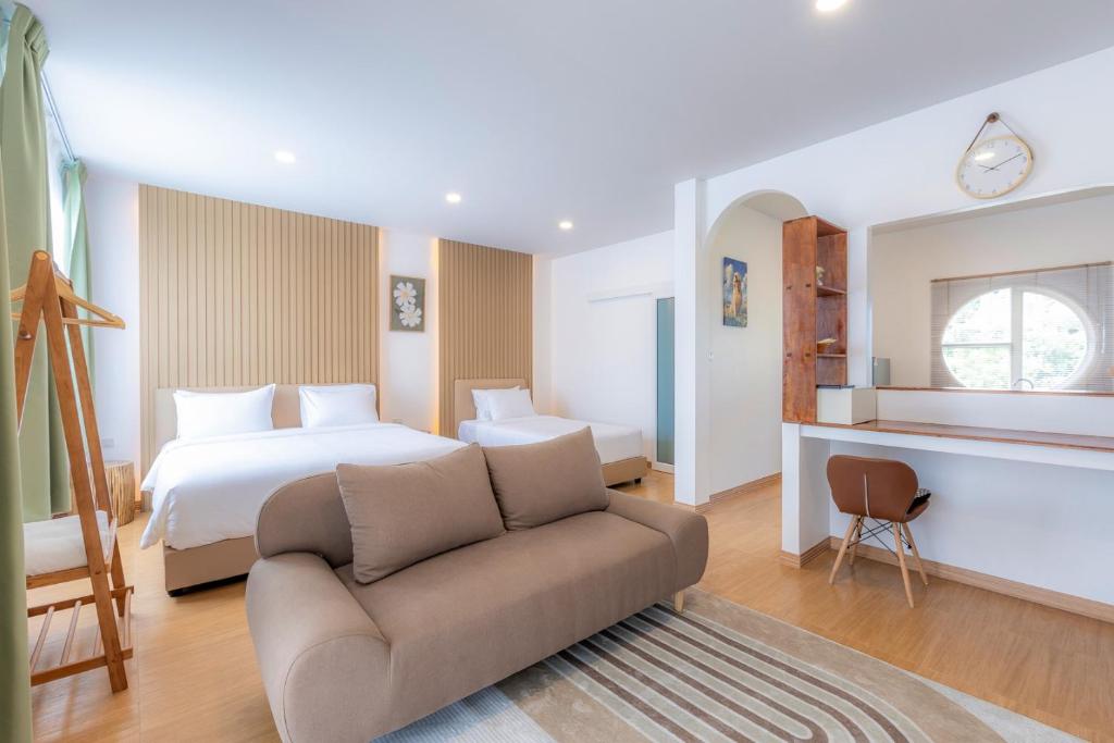 a hotel room with a bed and a couch at Sunrise Serenity Phuket Resort in Karon Beach