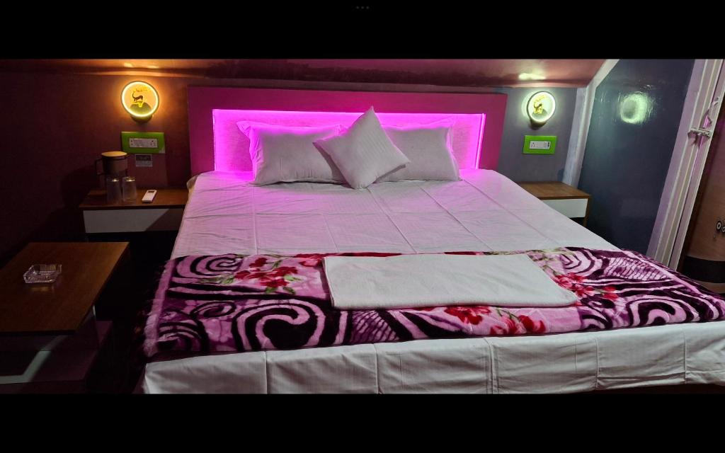 1 dormitorio con 1 cama grande con iluminación púrpura en Youon, en Bakkhali