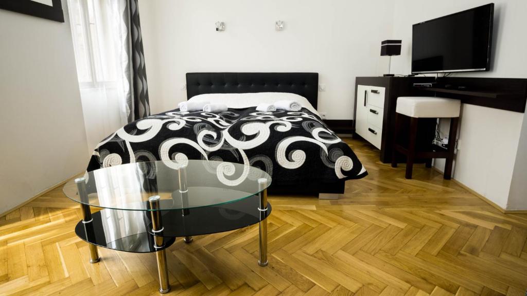 プラハにあるBlack & White Apartment Prague by Wenceslas Square and Muzeumのベッドルーム1室(ベッド1台、ガラス張りのテーブル付)