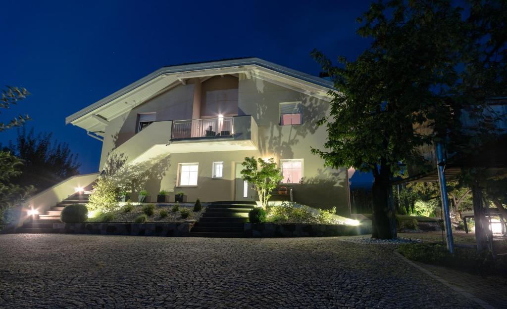 uma grande casa branca à noite com luzes em Ferienwohnungen Gamper em Tesimo
