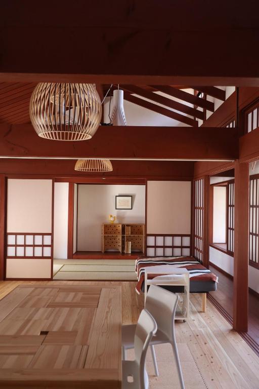 a room with a bed and a table and chairs at Essai B&B - Quiet Village Retreat in Gokayama, near Shirakawa-go in Nanto