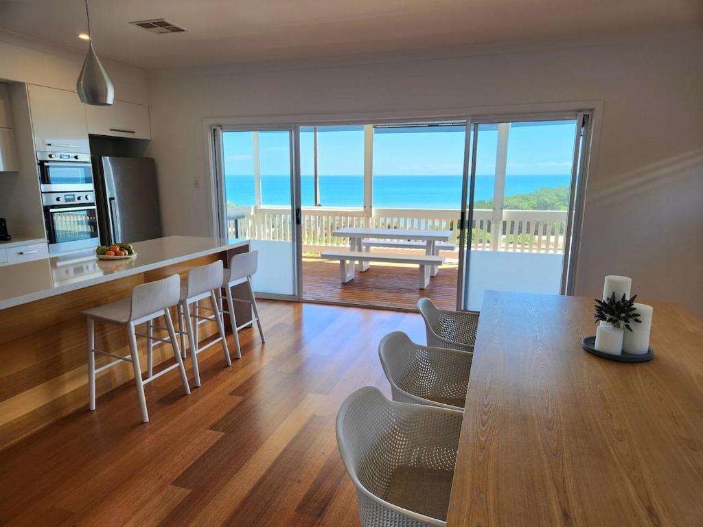 a kitchen and living room with a table and chairs at Beachfront Mid Coast Escape in Seaford