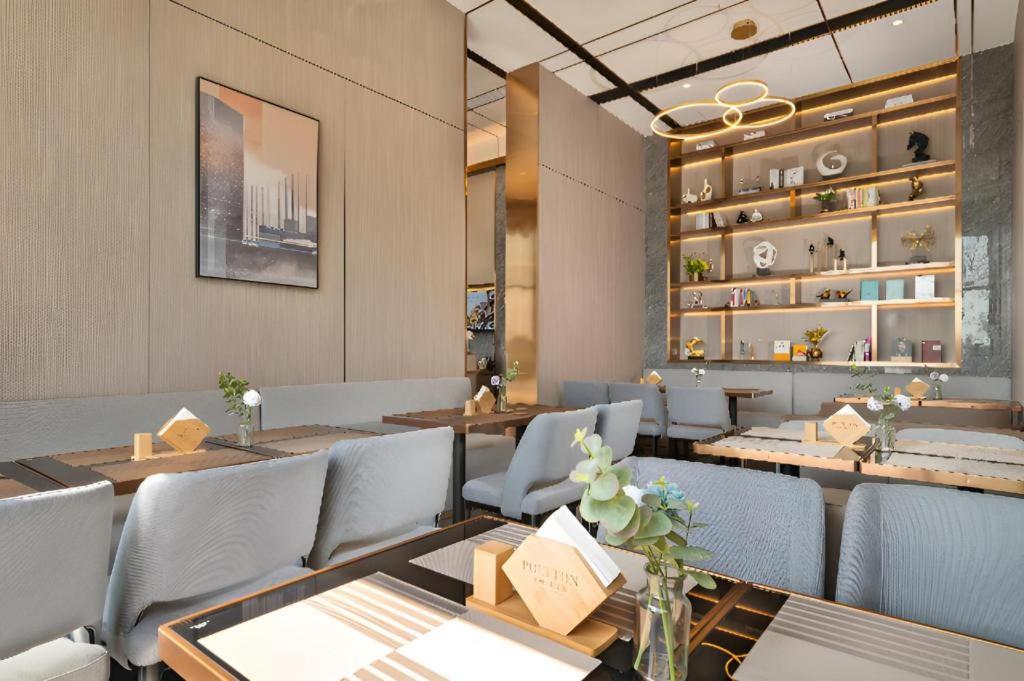 ein Restaurant mit Holztischen und blauen Stühlen in der Unterkunft Poltton International Service Apartment Shanwei Urban District High-speed Railway Station in Shanwei