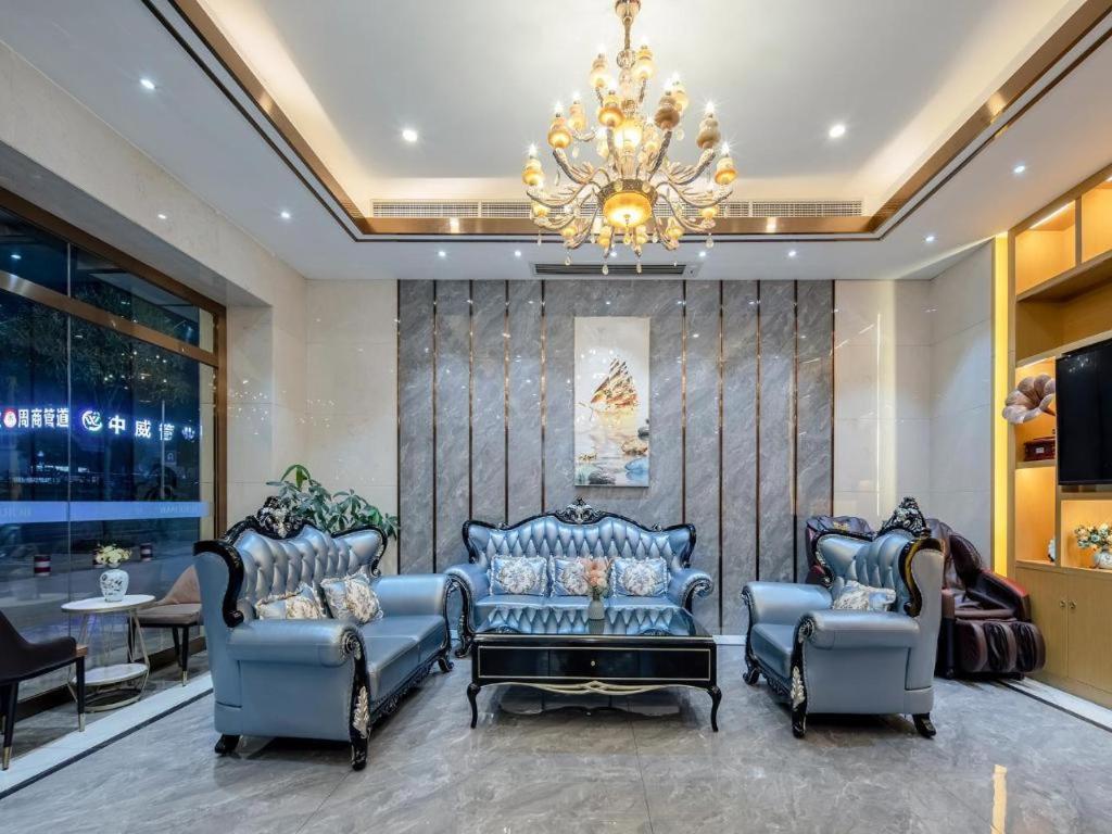 ein Wohnzimmer mit blauen Stühlen und einem Kronleuchter in der Unterkunft Borrman Hotel Nanning Anji Passenger Station Xijin Metro Station in Nanning