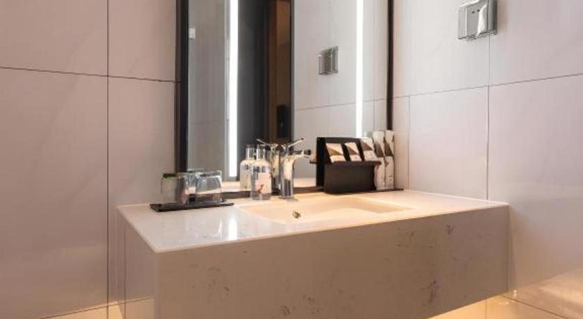 a bathroom with a sink and a mirror at Borrman Hotel Guilin Railway Station Two Rivers and Four Lakes in Guilin