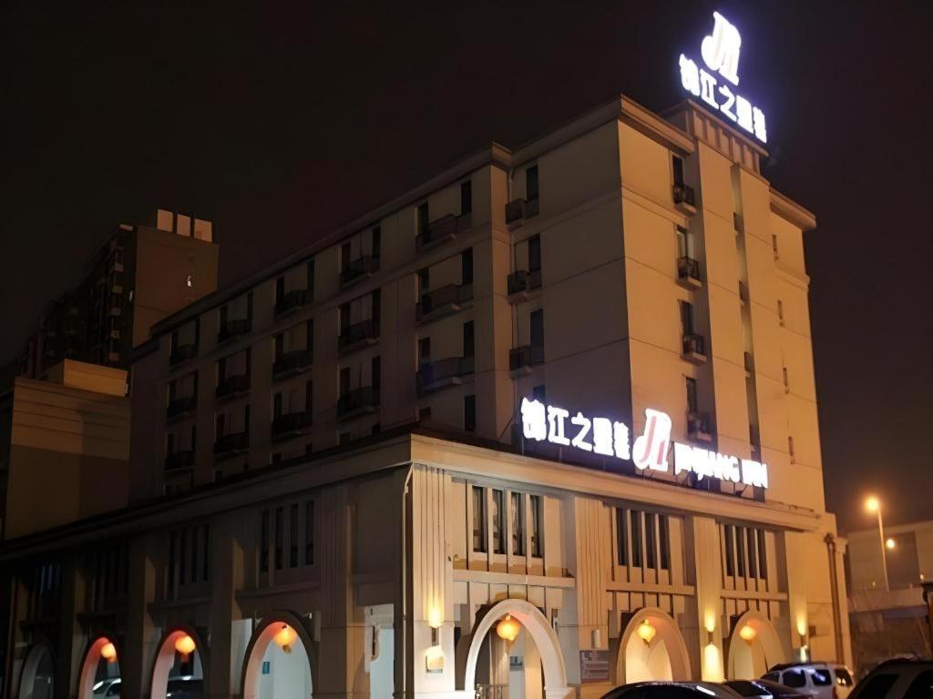 ein Hotelgebäude mit einem Neonschild darauf in der Unterkunft Jinjiang Inn Shenyang Xinggong North Street METRO in Shenyang