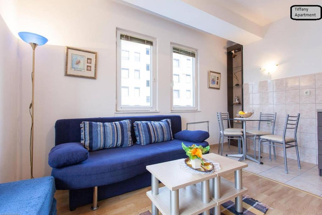 - un salon avec un canapé bleu et une table dans l'établissement Tiffany Apartment, à Ohrid