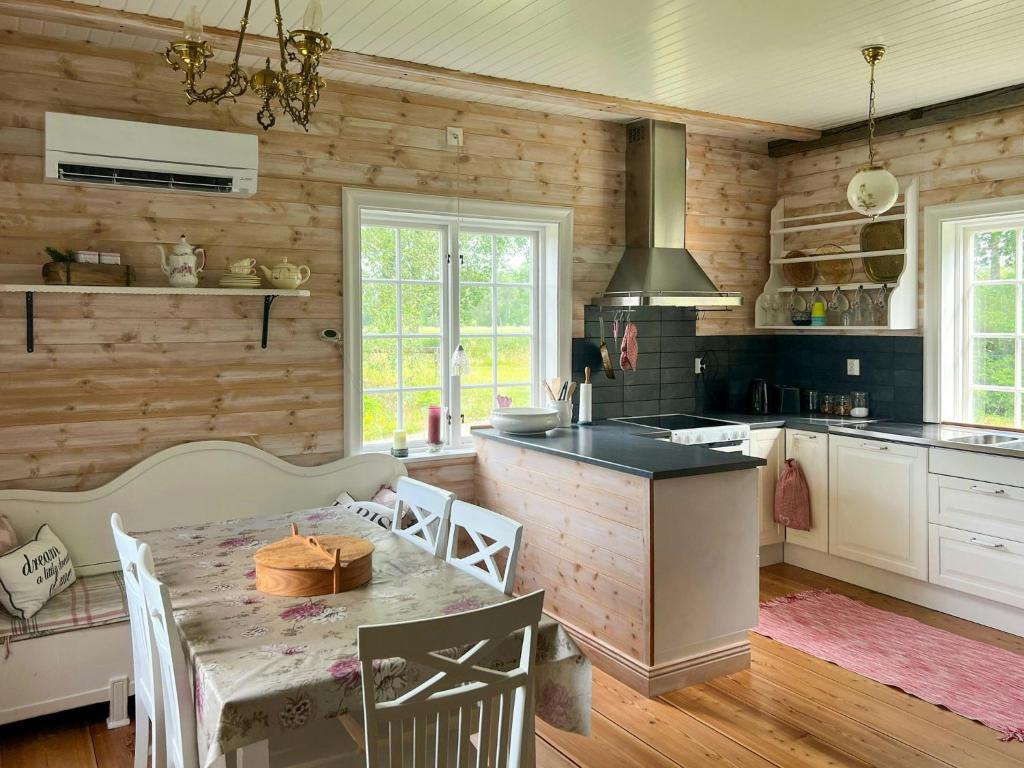 a kitchen with wooden walls and a table in a room at Historic Dock House In The Heart Of Småland in Hult