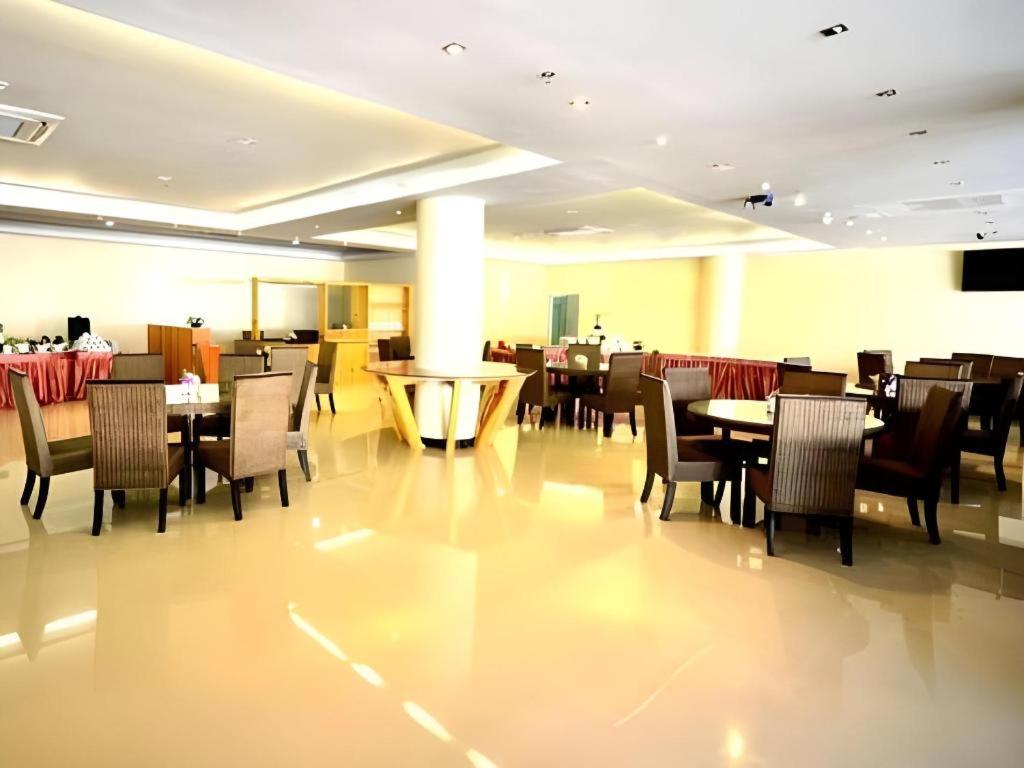 ein Speisesaal mit Tischen und Stühlen in einem Restaurant in der Unterkunft Piyaporn Pavilion Hotel in Mae Sai