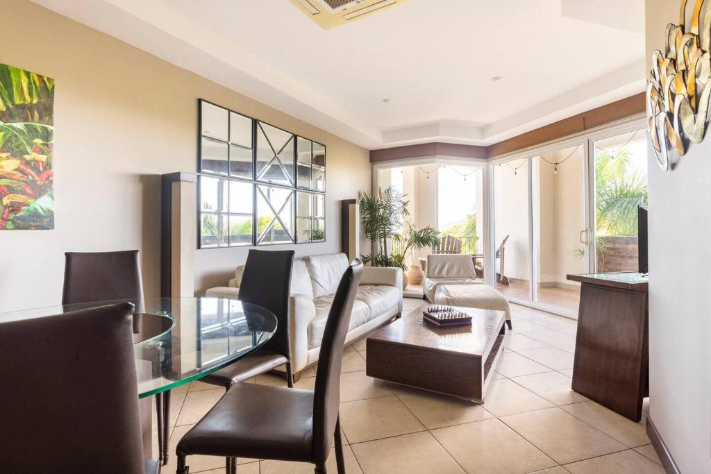 a living room with a couch and a glass table at Peninsula Langosta in Tamarindo