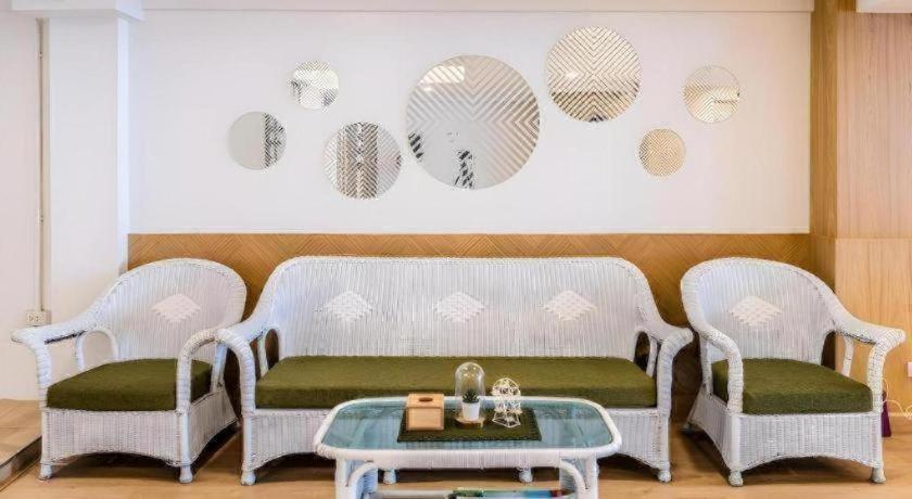 two wicker chairs and a table in a room at Magic House Hostel in Cha Am