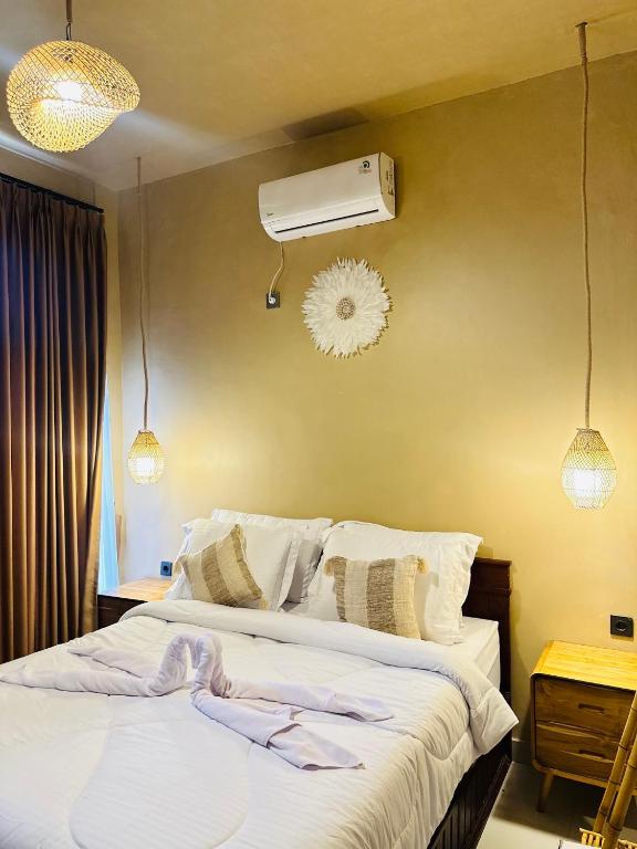 a bedroom with a bed and a air conditioner on the wall at Pinggan heaven in Gretek