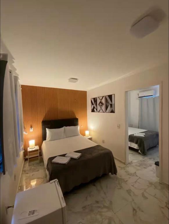 a bedroom with a large bed in a room at Charlotte Beach Inn in Mangaratiba