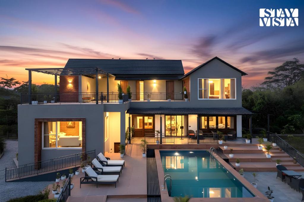 a house with a swimming pool at sunset at StayVista at Villa Aera with Pool, Lawn in Chandīgarh