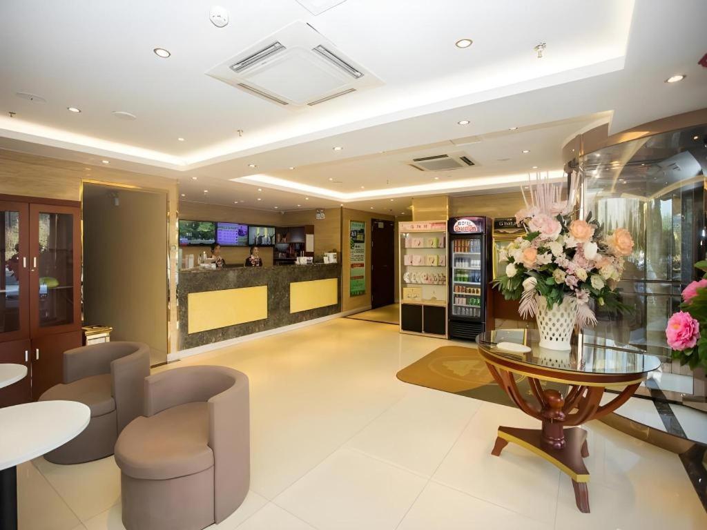eine Lobby eines Ladens mit einem Tisch und Blumen in der Unterkunft GreenTree Inn Luoyang Zhongzheng Street Express Hotel in Luoyang