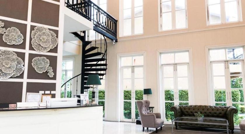 ein Wohnzimmer mit Treppe und Couch in der Unterkunft Verona Boutique Hotel - The Verona Co., Ltd in Ban Wang Khon Daeng