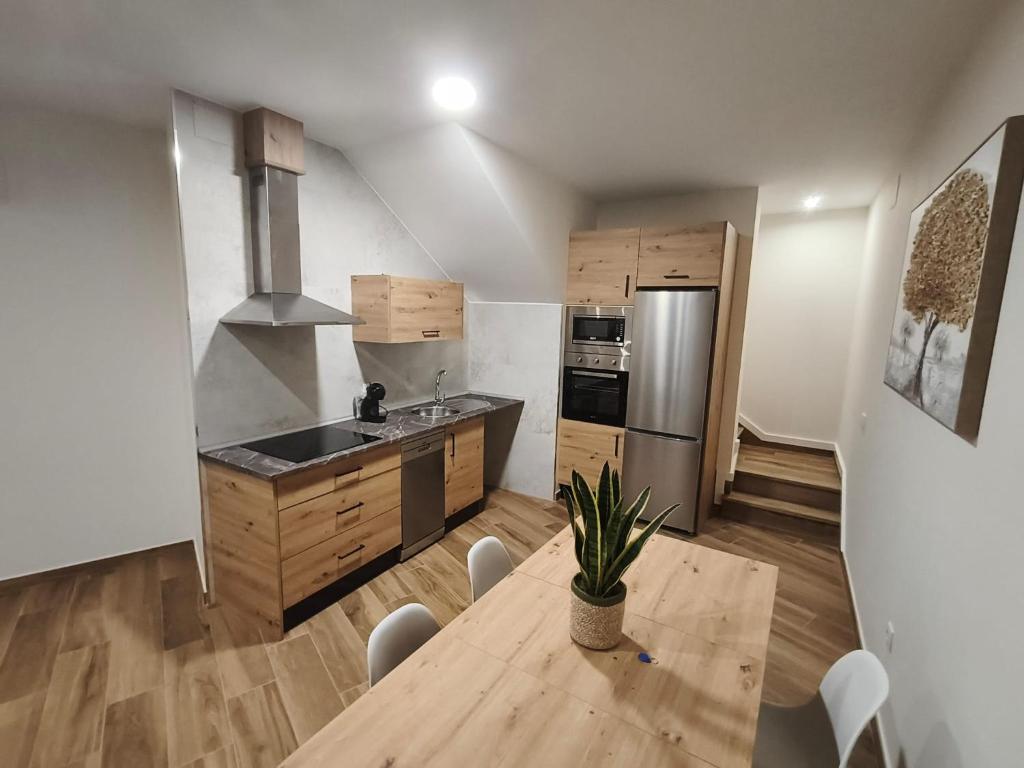 eine Küche mit Tisch und Edelstahlkühlschrank in der Unterkunft El Huertecillo in Villanueva de los Infantes