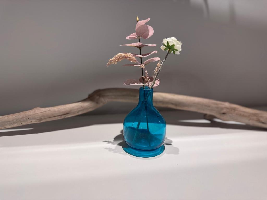un vase bleu avec des fleurs dedans sur une table dans l'établissement Möbliertes Familienhaus in Hamburg, à Niederdorla