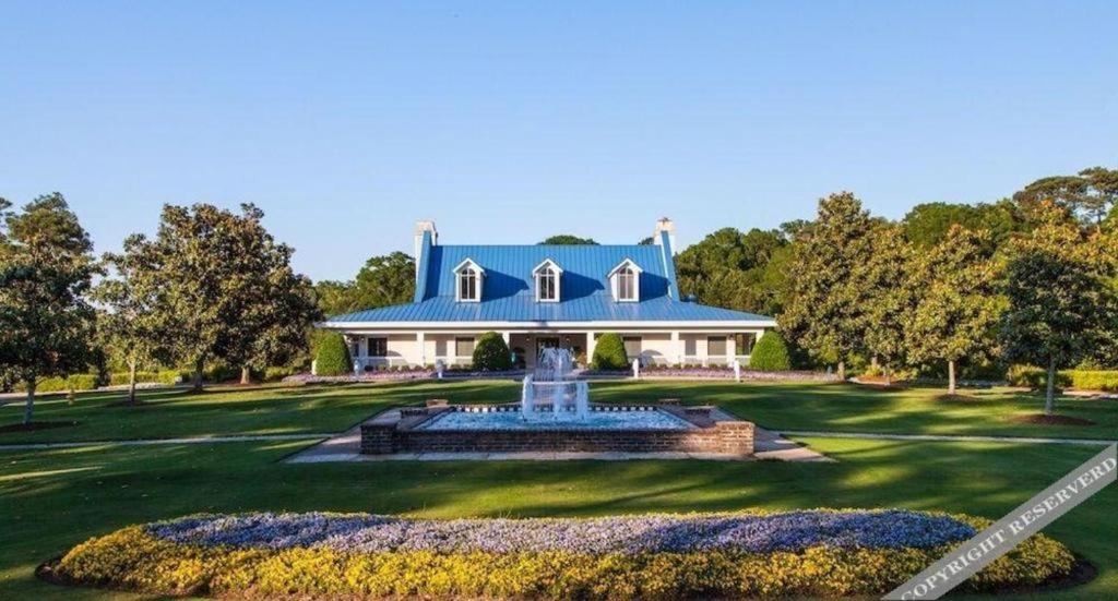 ein Haus mit blauem Dach und einem Brunnen in der Unterkunft True Blue Golf Resort in Pawleys Island