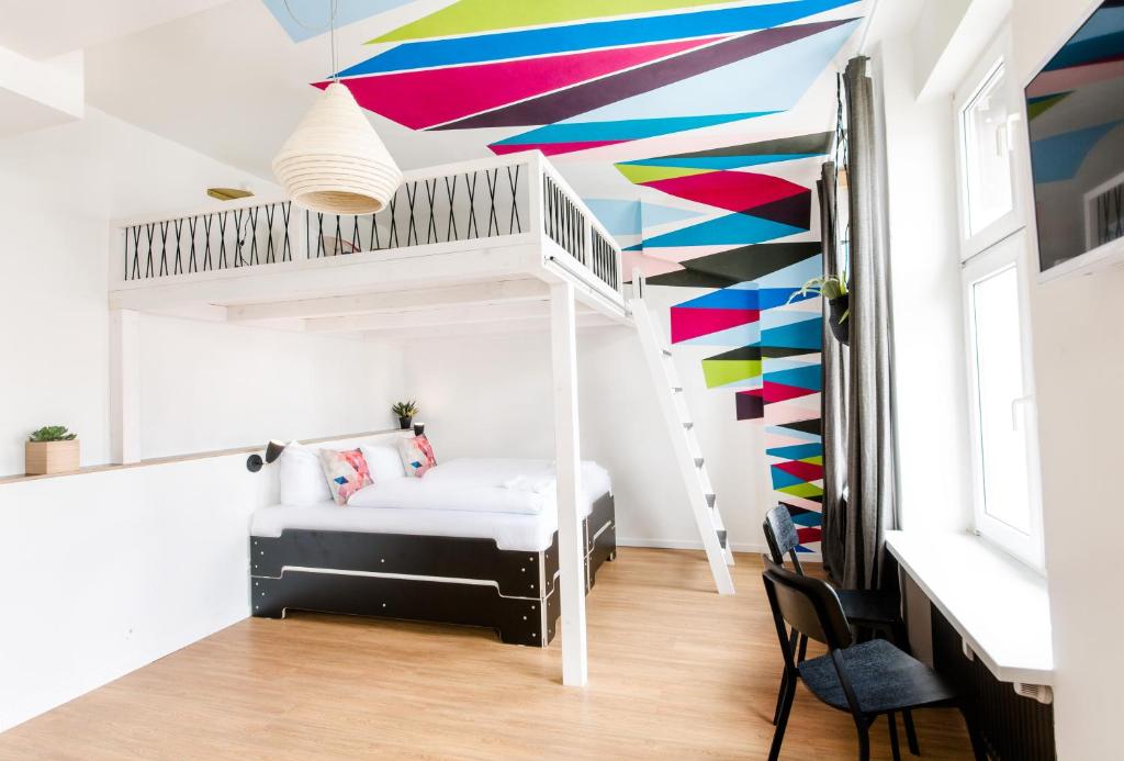 a bedroom with a bunk bed with a colorful ceiling at Pyjama Park Schanzenviertel in Hamburg
