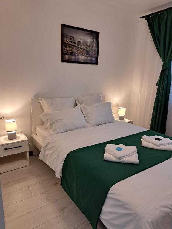a bedroom with a large bed with towels on it at Mia Apartments in Craiova