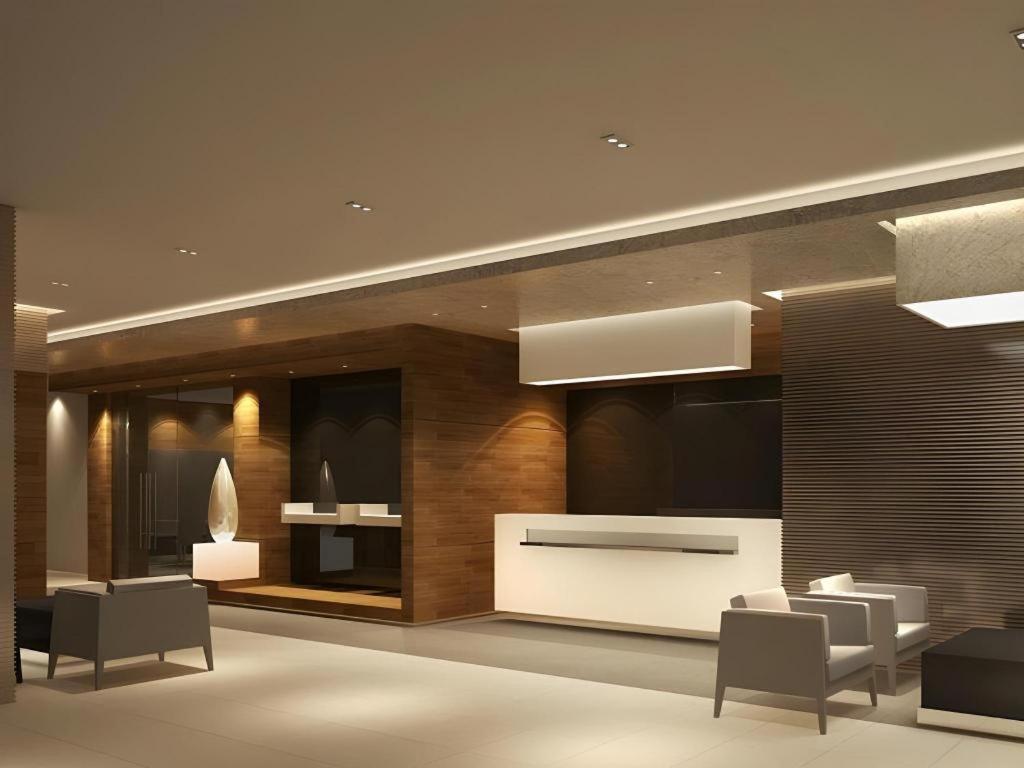 ein Wohnzimmer mit Stühlen, einem Tisch und einer Wand in der Unterkunft Jinjiang Inn Yantai Penglaige Zhonglou North Road in Penglai